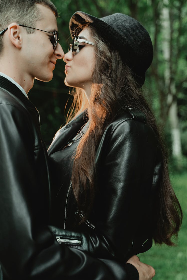 Young Couple In Leather Jackets And Sunglasses Hugging