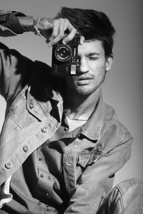 Free Black and white portrait of a man posing with a vintage camera in Indore, India. Stock Photo