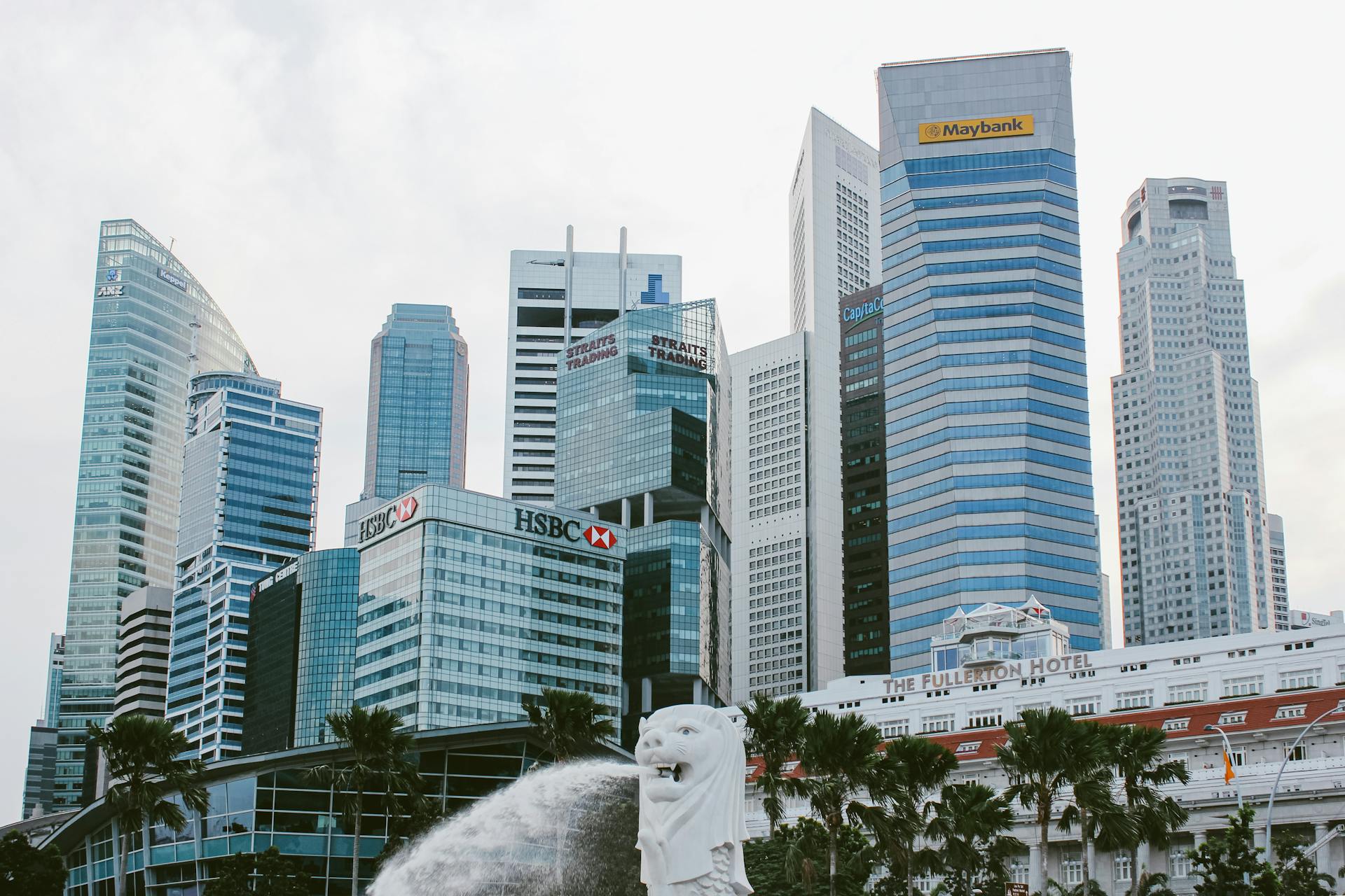 Skyline of Singapore with iconic Merlion and skyscrapers in the bustling financial district.