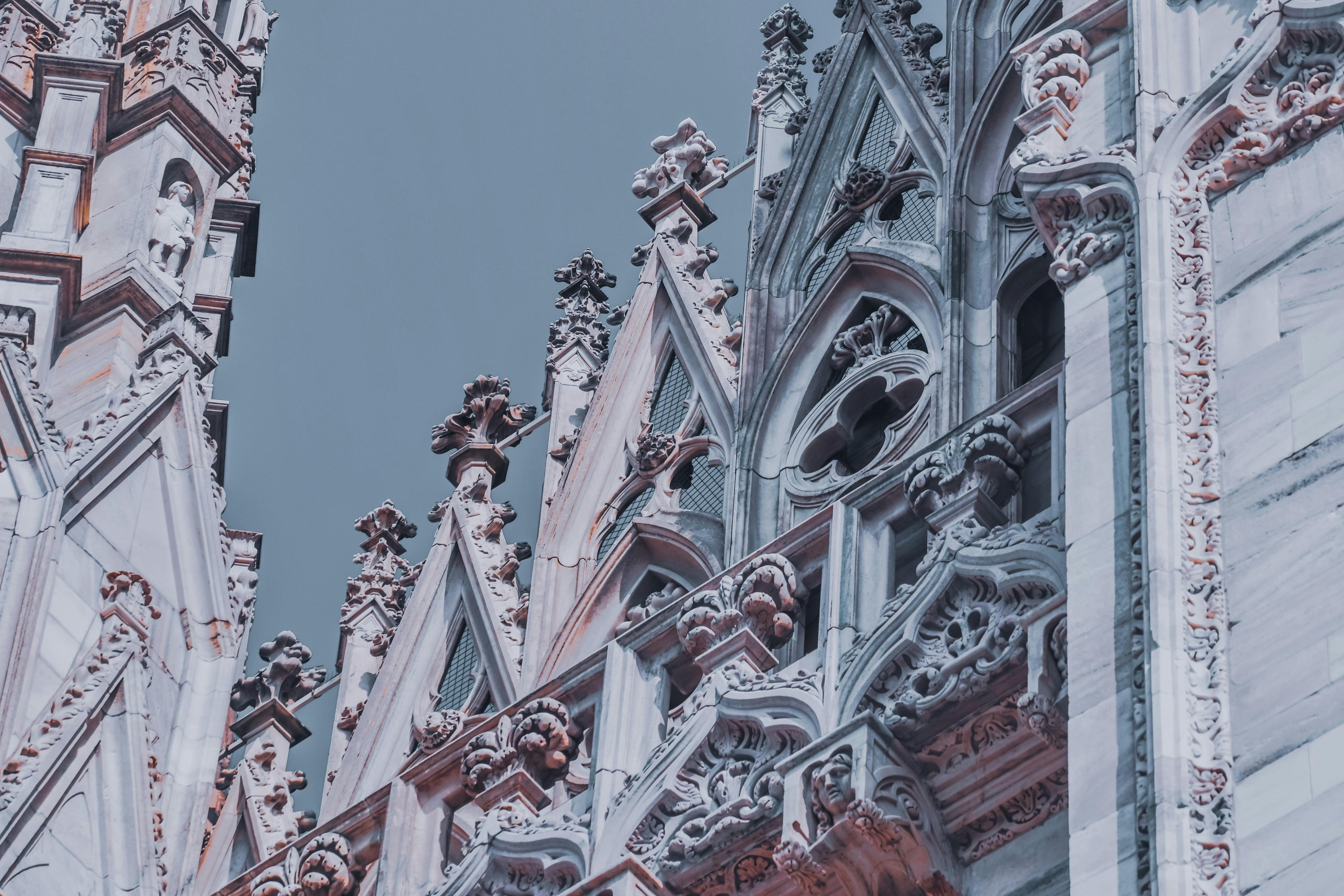 carved spire and sculptures on marble facade of catholic cathedral