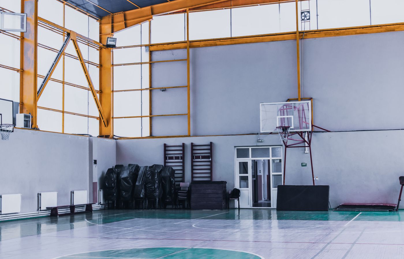 Spacious indoor basketball court featuring modern architecture, perfect for fitness and sports activities.