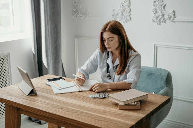 Doctor Writing On A Notebook