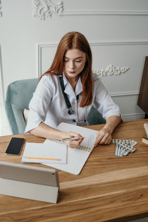 Free Photo Of Woman Writing On A Desk Stock Photo