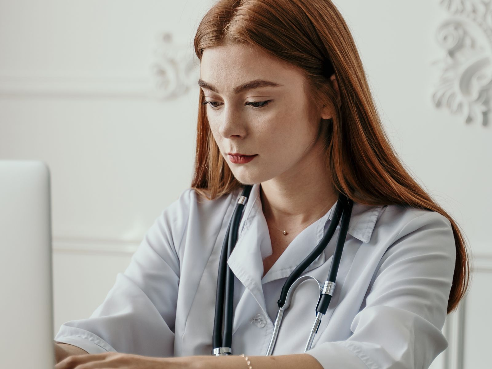 Healthcare professional using a laptop or tablet in a modern practice office