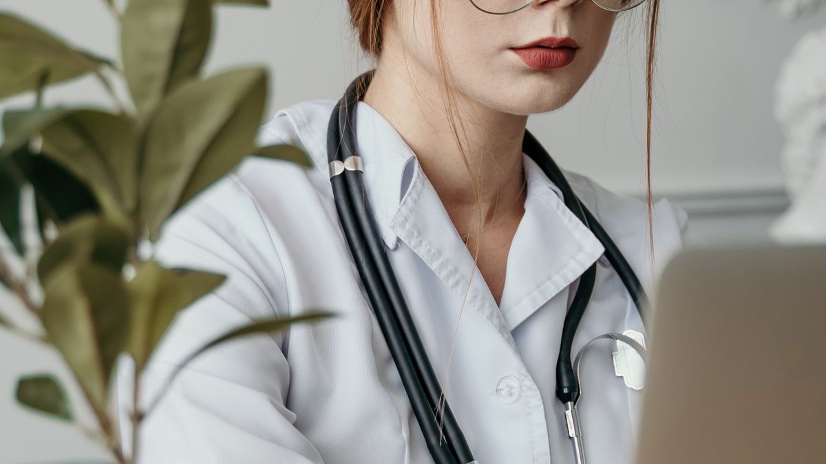 Doctor using a laptop, relevant to healthtech AI UX and compliance