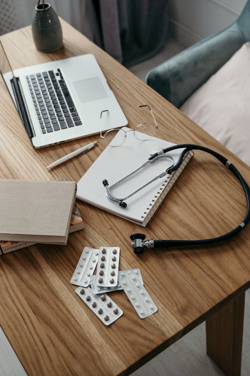 Medicine and a Stethoscope on a Wooden Table Top 