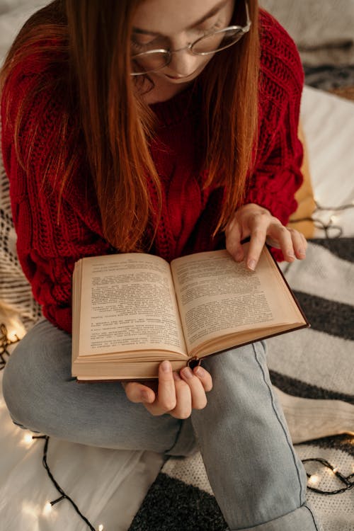 Free Woman in Red Sweater Reading Book Stock Photo