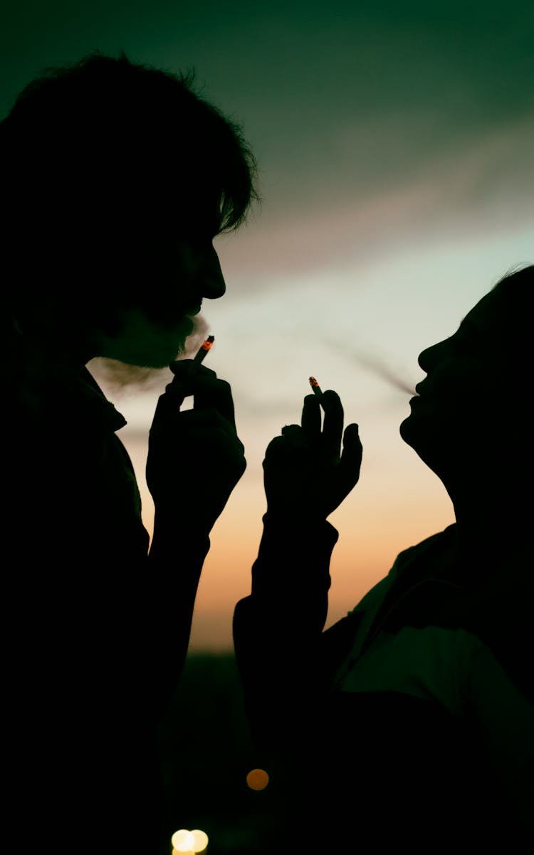 Silhouette Of Man And Woman Smoking Cigarette