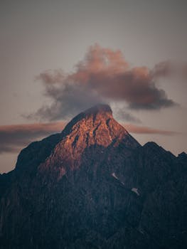Magnificent landscape of rough rocky cliff with gray cloud on top at sundown