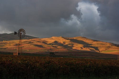 Windmill placed on field against hill