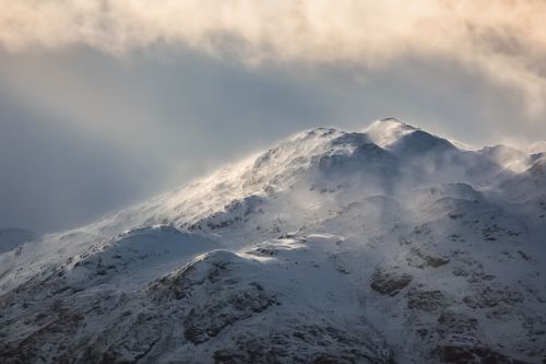 Free Spectacular scenery of rocky mountains covered with snow in windy day under cloudy sky Stock Photo