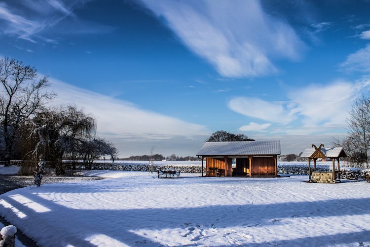 Brown Wooden House On Snow Covered Ground Under Blue Sky