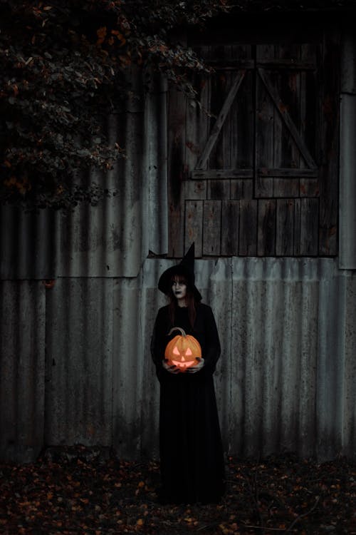 Witch Standing With a Pumpkin in Her Hands