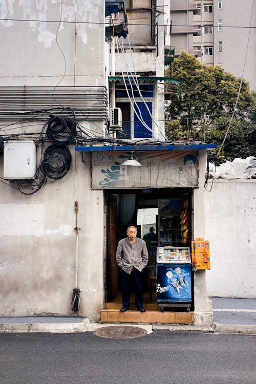 Elderly Man Standing in Front of Store