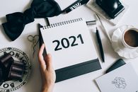 桌面布局时尚扁平，配有2021年日历、领结、巧克力和咖啡杯