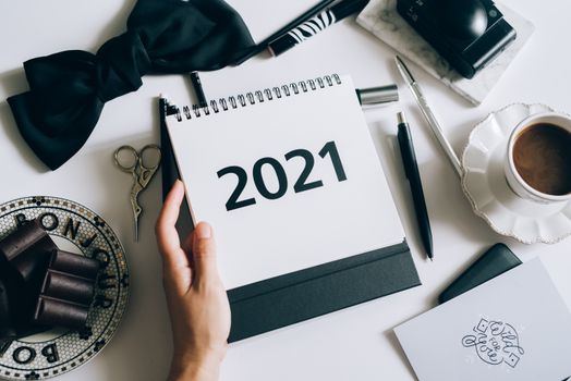 桌面布局时尚扁平，配有2021年日历、领结、巧克力和咖啡杯