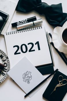 2021年优雅的规划师平面布置，周围环绕着文具、化妆品和咖啡，非常适合激发规划灵感