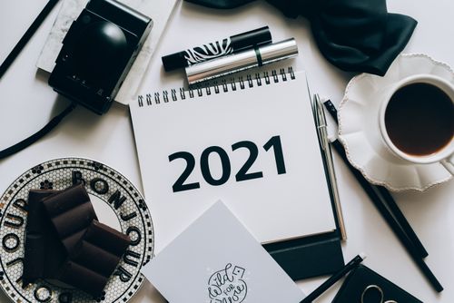Free Stylish desktop flat lay featuring a 2021 calendar, chocolate, and coffee. Stock Photo