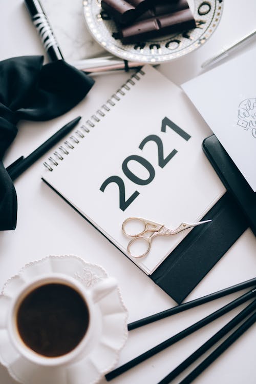 A Pair of Scissors on a 2021 Desk Calendar Beside a Pen
