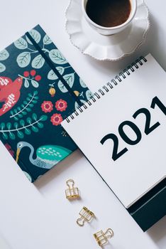这个时尚的平面布置配有2021年计划器、咖啡和文具，方便组织任务