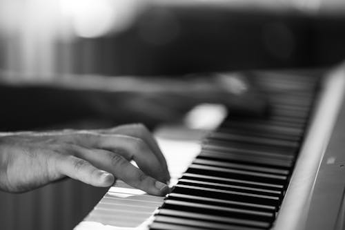 A Person Playing Piano in Grayscale Photography