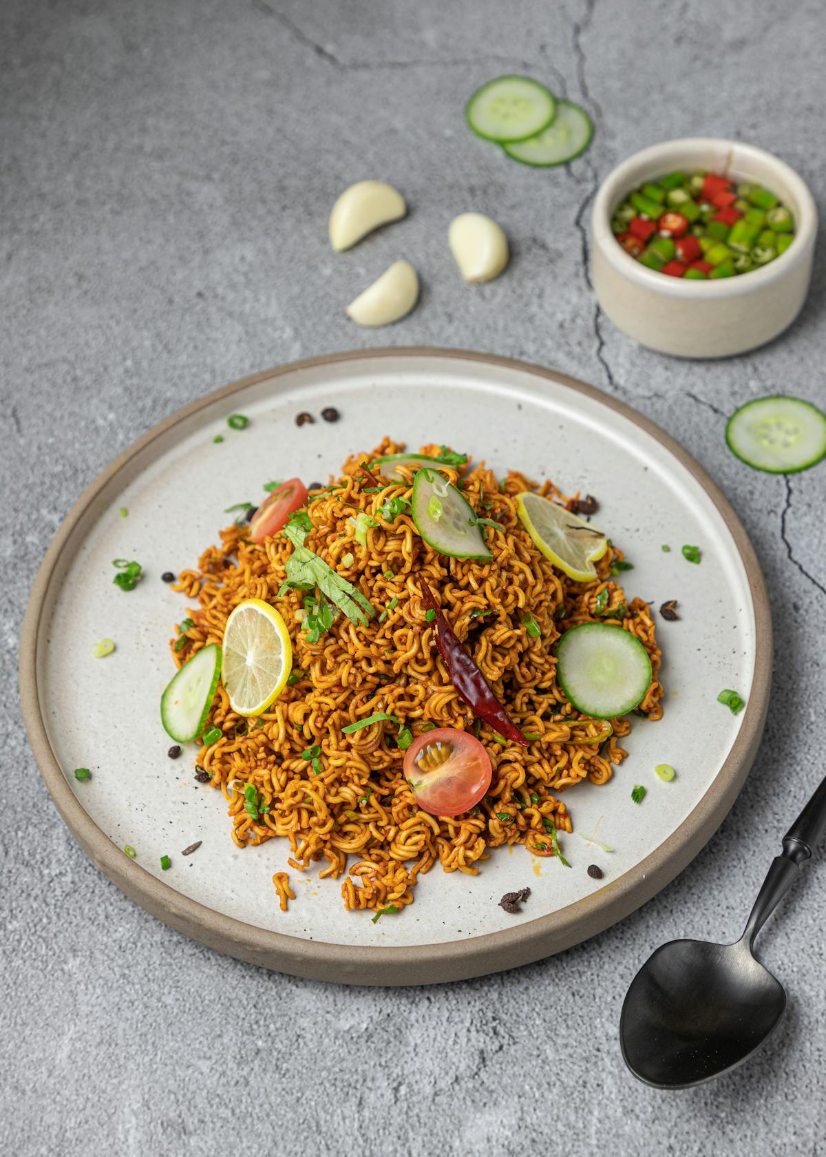 Spaghetti piccanti guarniti con sottili fette di agrume su piatto