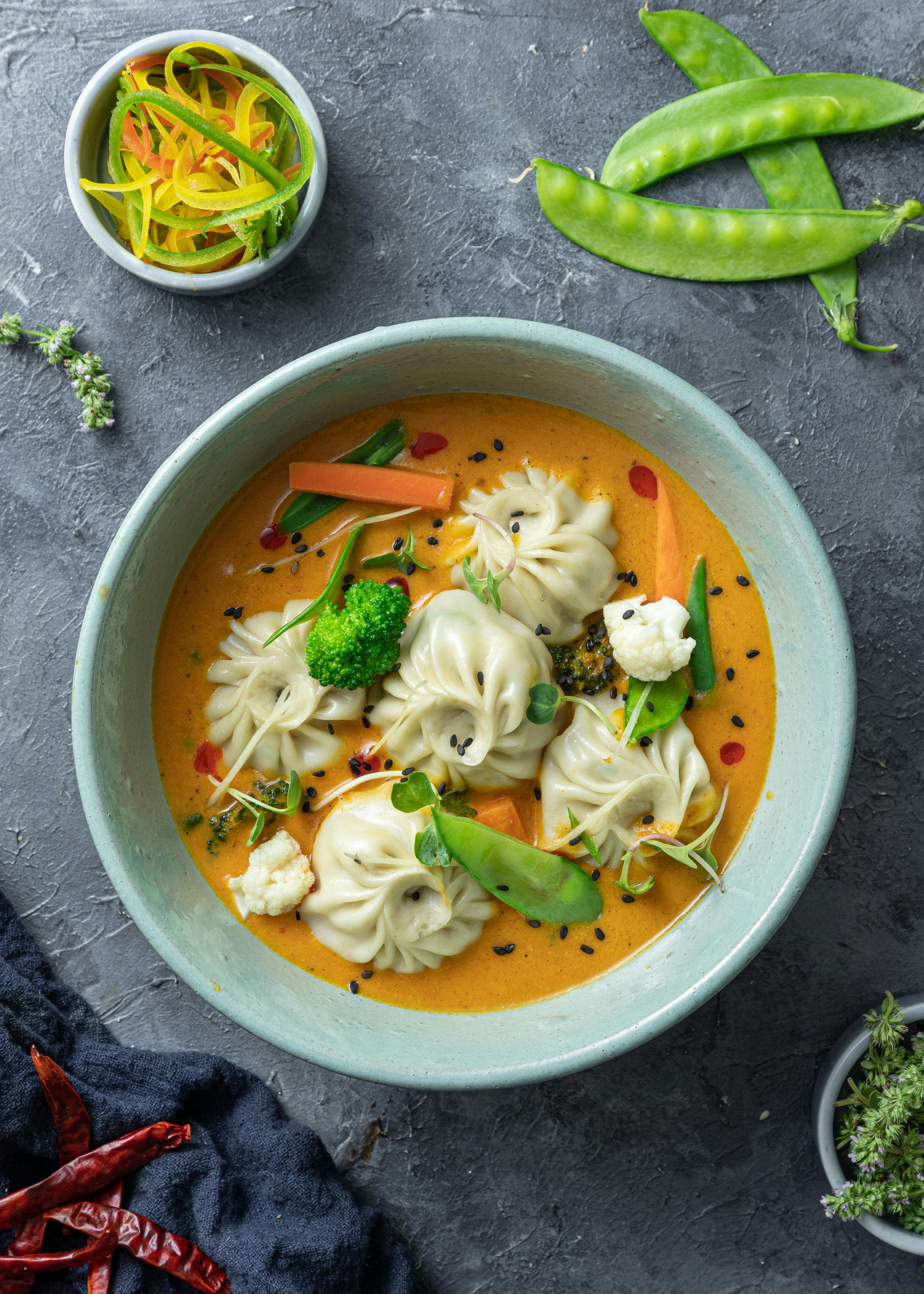 soup with dimsums and vegetables on ceramic bowl