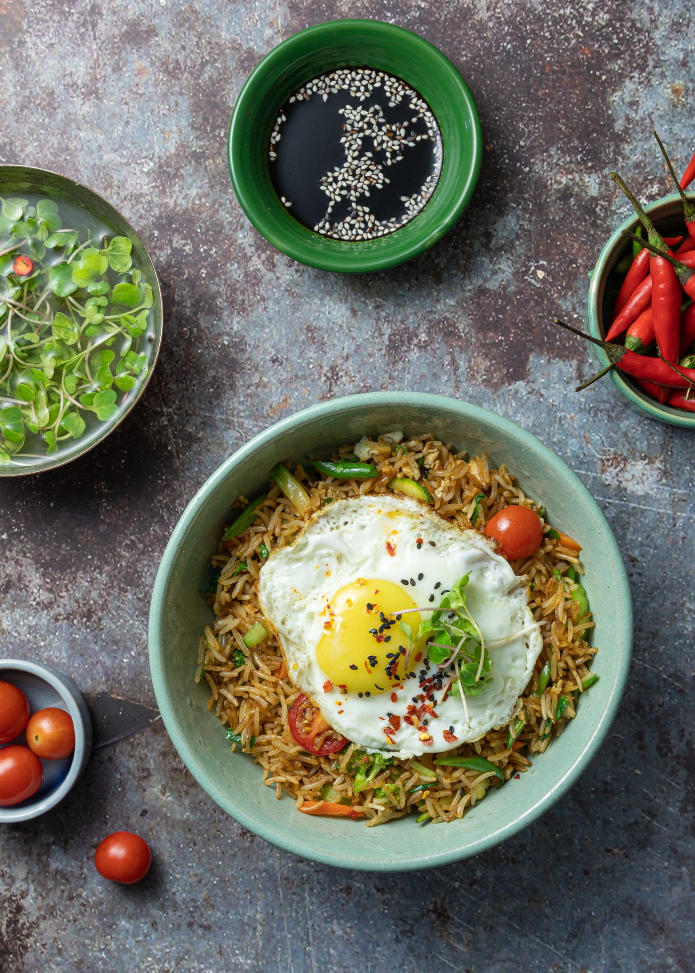 Bowl of fried rice with vegetables and a fried egg on top