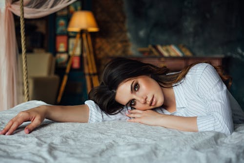 Sensual brunette leaning on bed