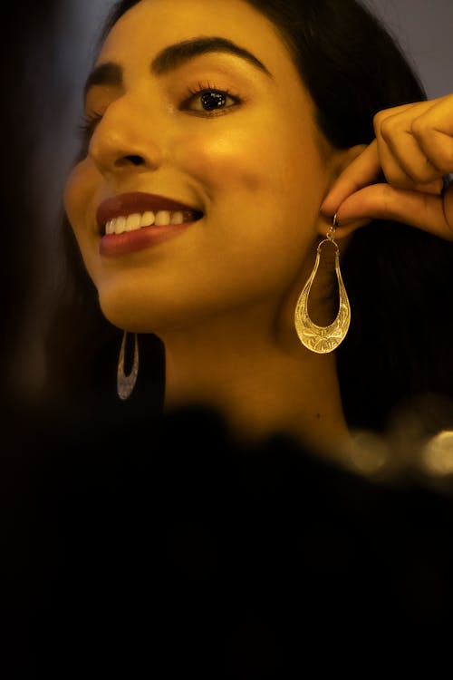 Woman Putting on U Shape Silver Earrings