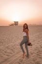 Woman strolling on beach at sunset
