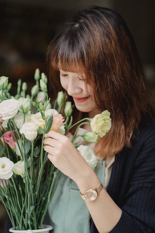 生花の花束をかぐエスニック笑顔の女性