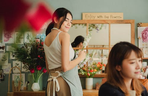 Smiling florist making bouquet in stylish shop
