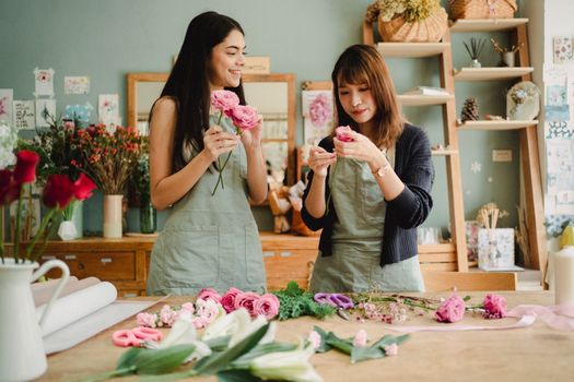 在舒适的工作室里，两名女花师正排列花束，创作美丽的花卉设计