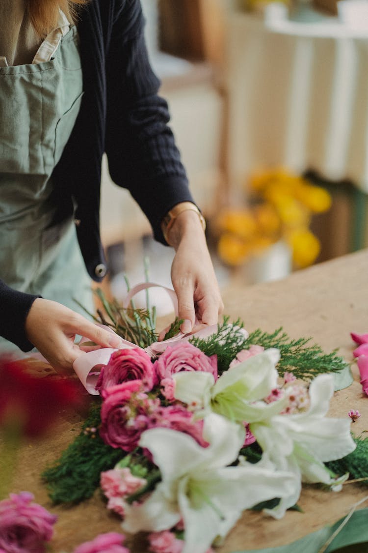 Florist Arranging Flowers In Bouquet With Ribbon