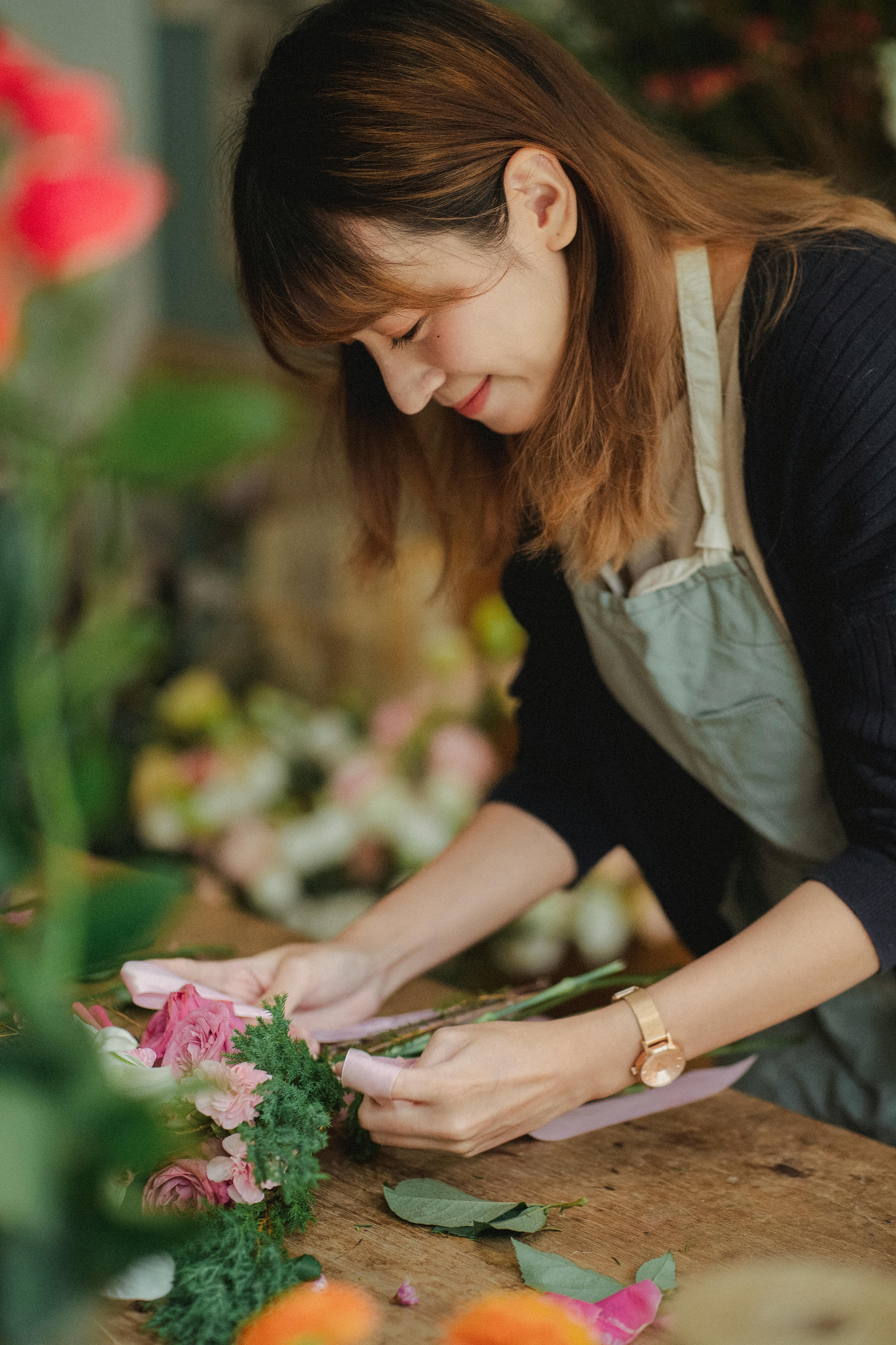 positive ethnic florist making bouquet in floral shop