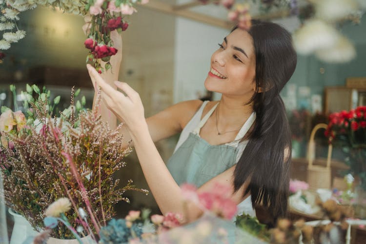 Happy Woman With Flowers During Work