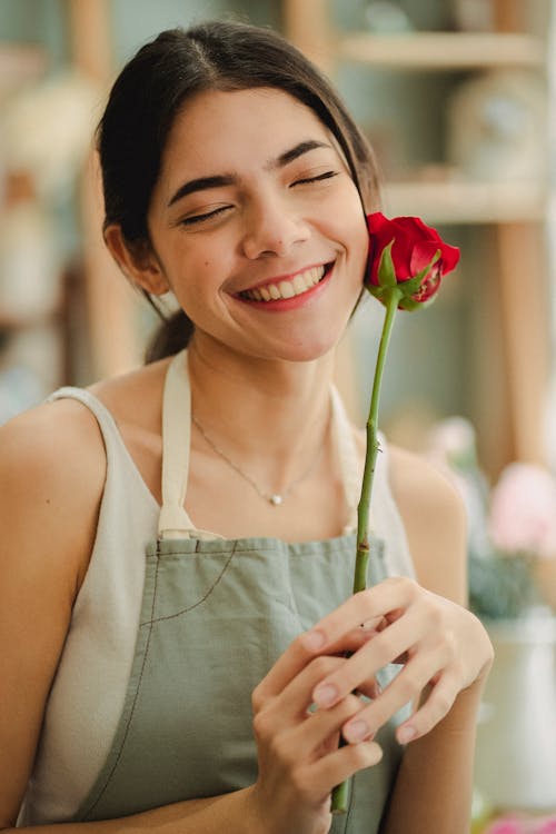 Floristería Sosteniendo Flor Y Sonriendo En La Tienda