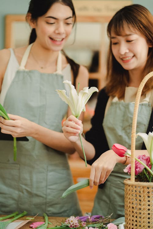 Contenu Des Cultures Collègues Asiatiques Interagissant Tout En Travaillant Dans Un Magasin De Fleurs