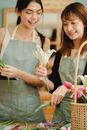 Crop content Asian colleagues interacting while working in flower shop