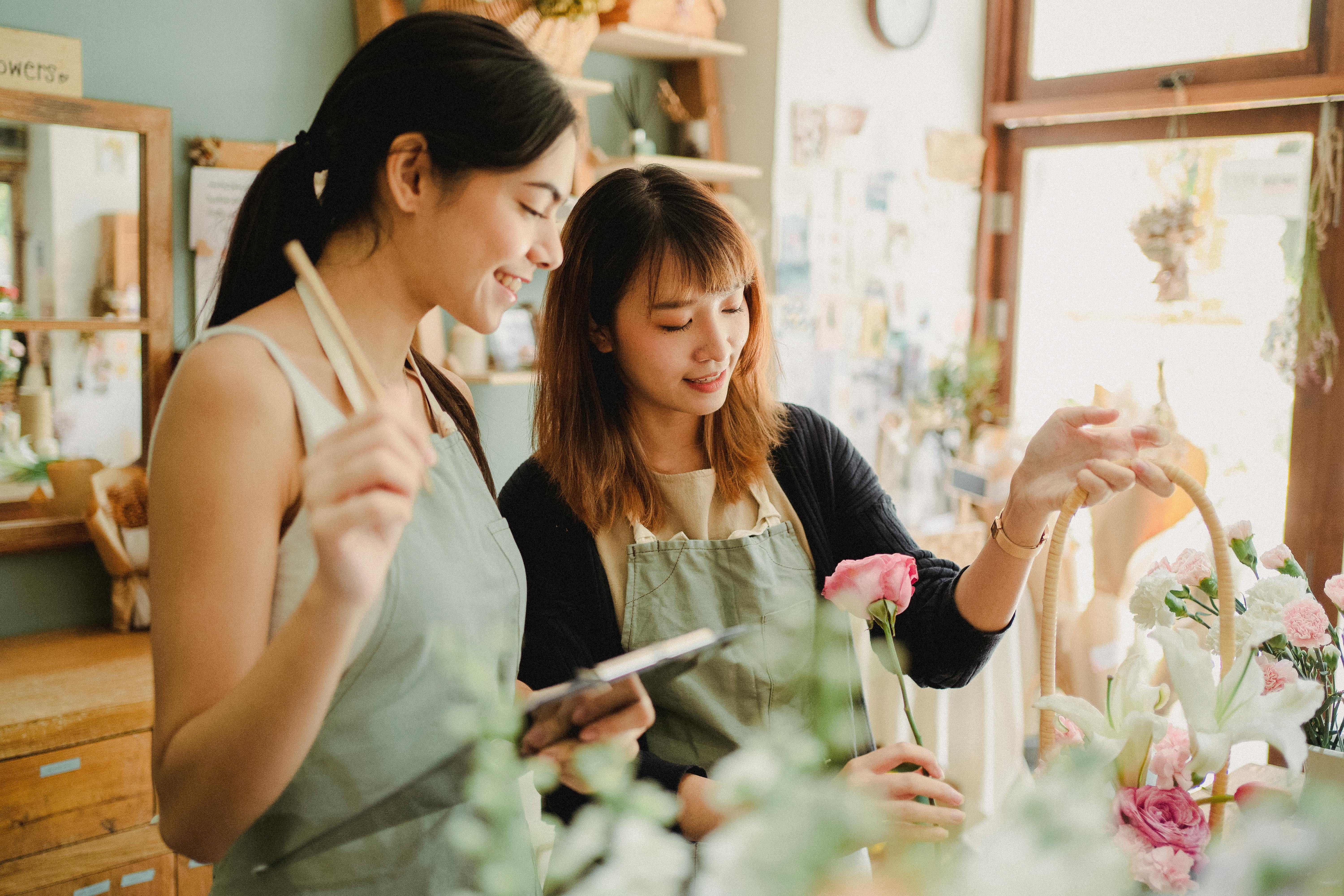 content asian florists preparing flower bouquet to order in shop