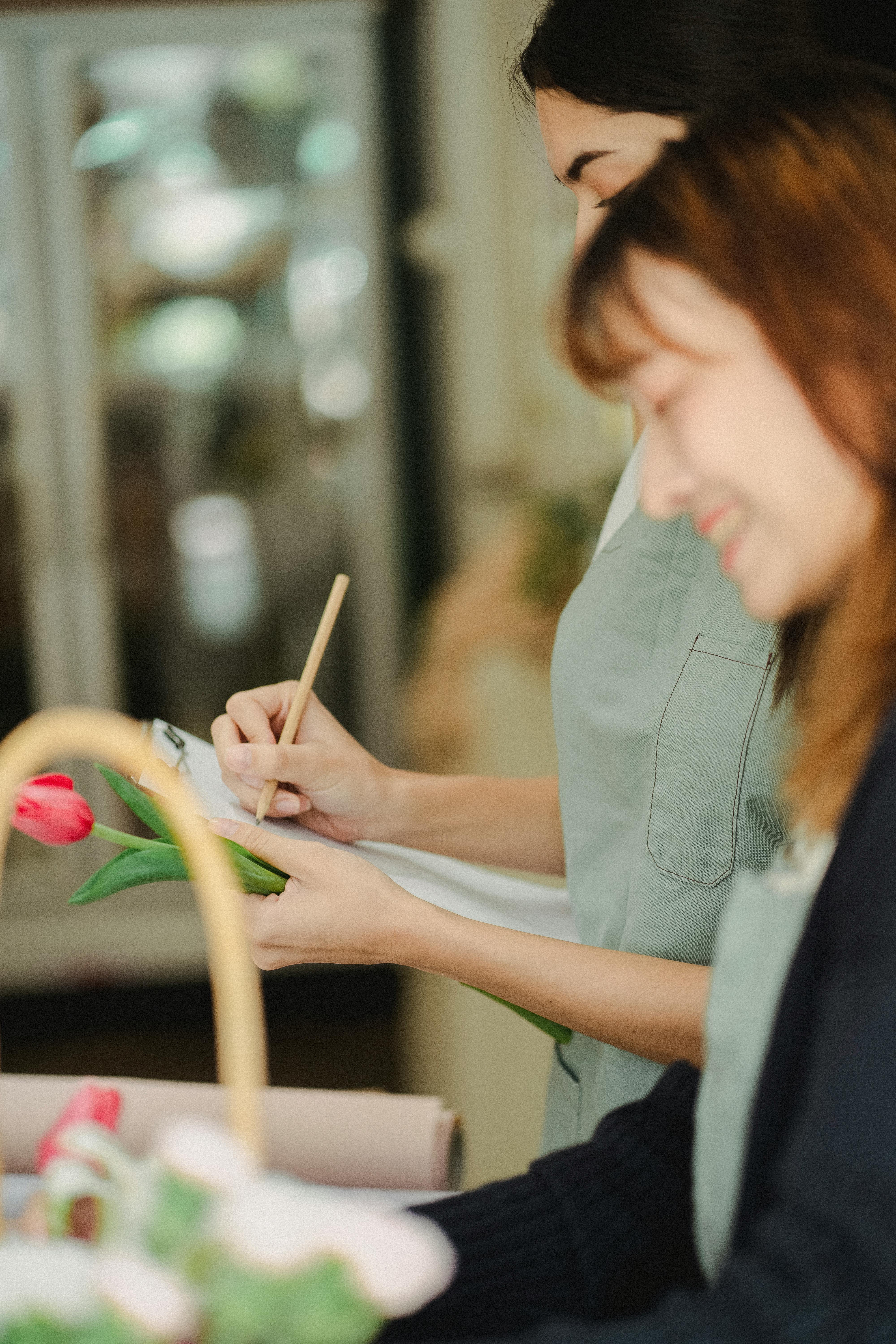 unrecognizable multiracial women with clipboard in floral shop