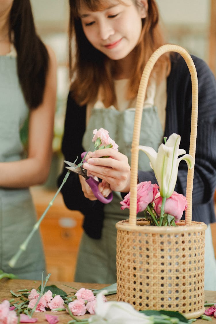 Positive Asian Woman Cutting Stems Of Flower