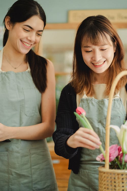 Улыбающиеся многорасовые женщины создают порядок в цветочном магазине