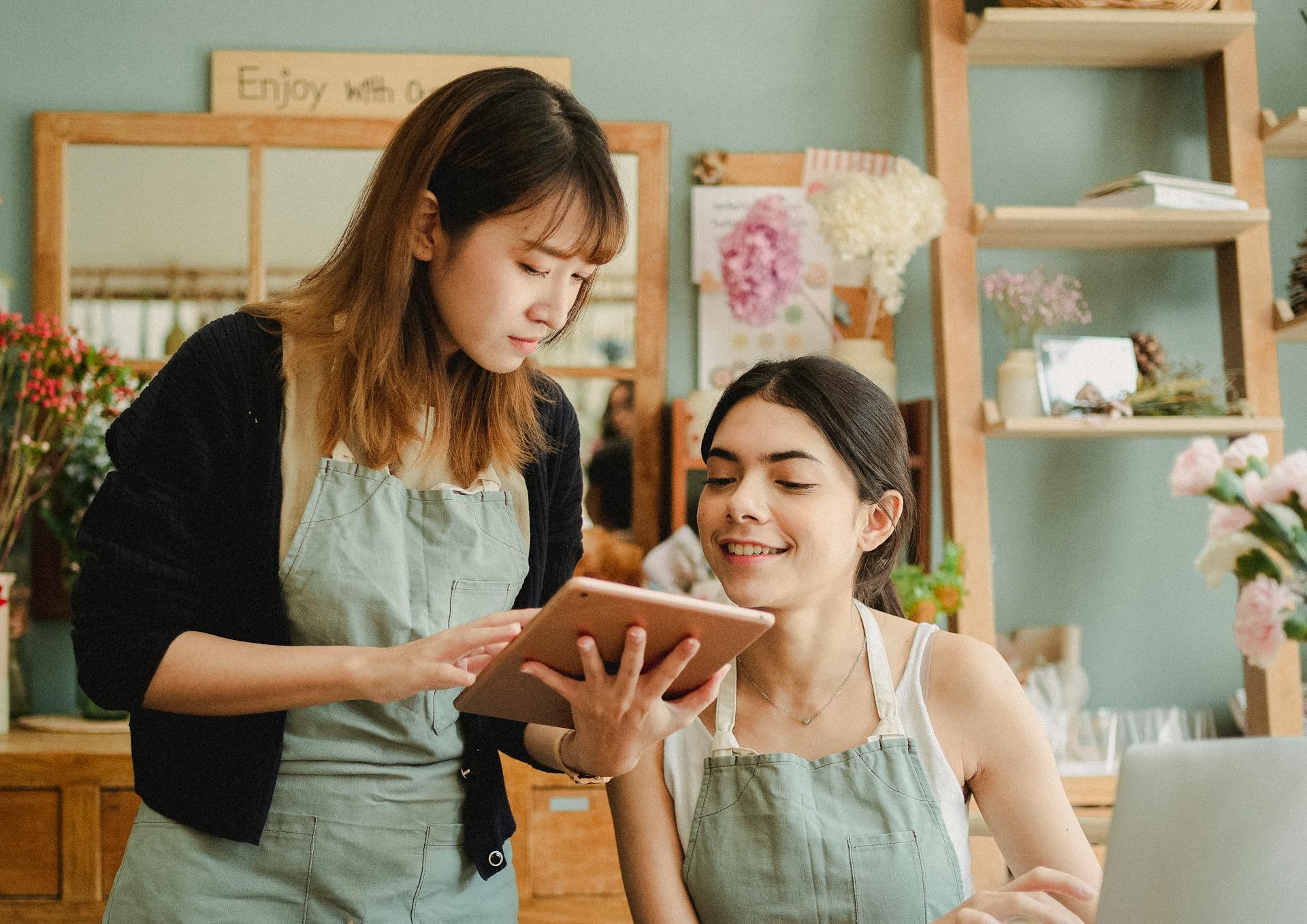 Focused multiracial women with tablet in workshop