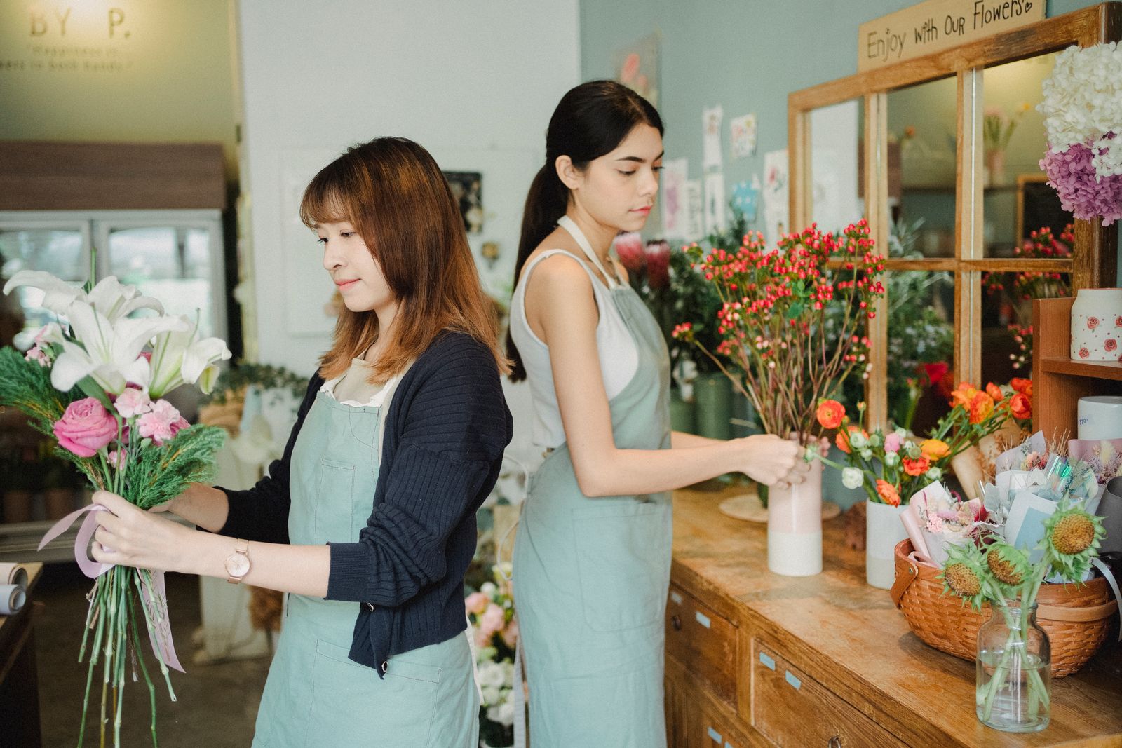 Two Florelle florists arranging fresh bouquets at the studio counter