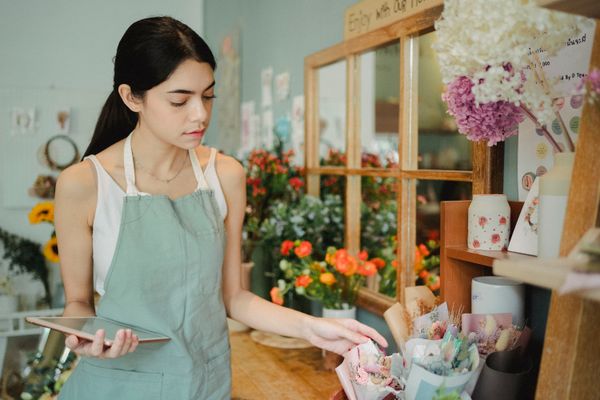 Small business owner checking costs and orders on a tablet