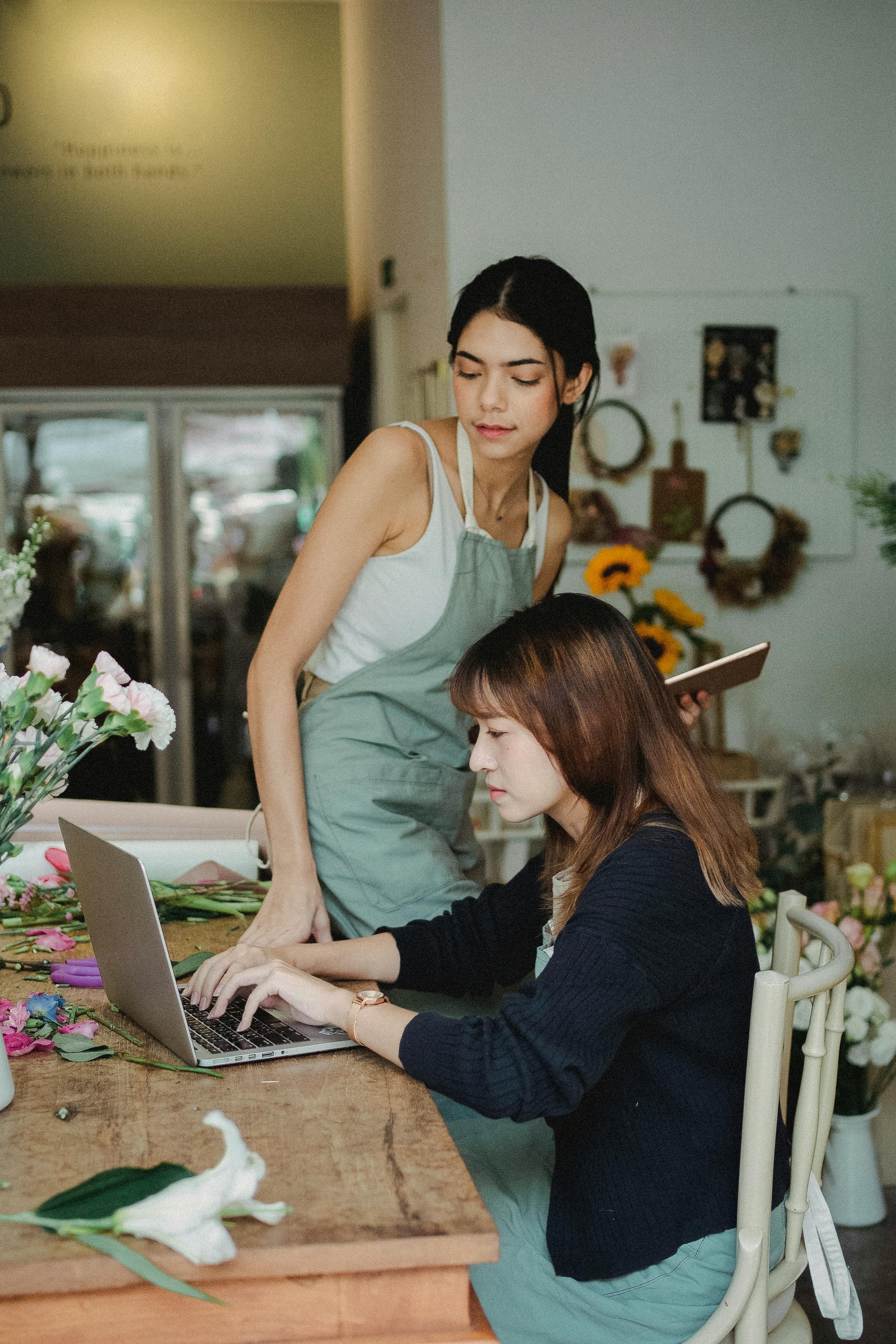 wistful multiracial florists working on laptop