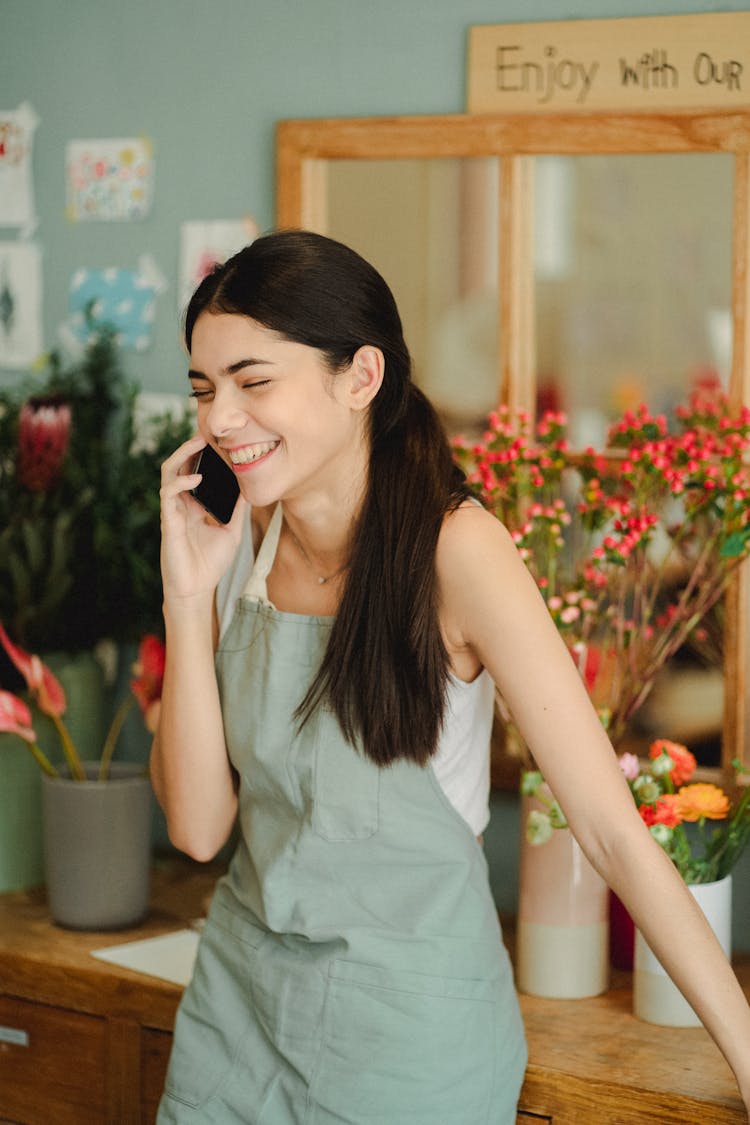 Smiling Woman Speaking On Phone In Floral Store