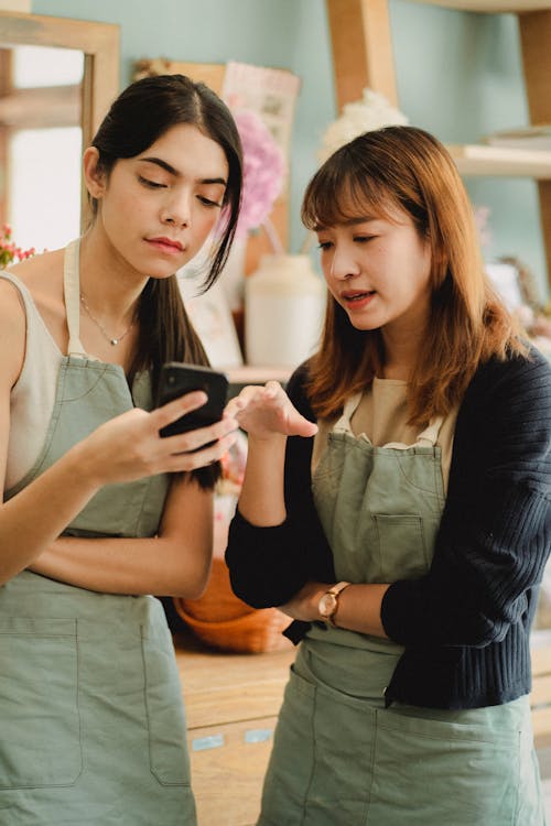 Jeunes Femmes Multiraciales Avec Smartphone En Boutique